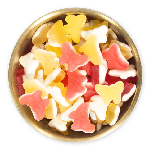 Pink and Yellow Butterfly gummy candies in a brass bowl on a white background