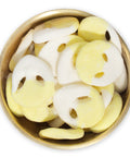 yellow and white alien gummies in brass bowl on white background