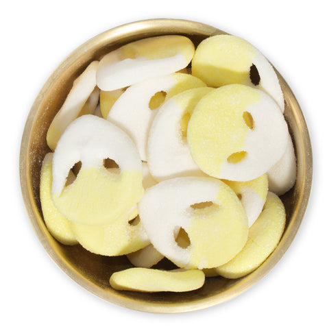 yellow and white alien gummies in brass bowl on white background