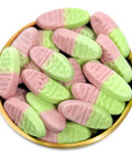 Pink and light green candy, each embossed with Rimbies', piled in a round gold-rimmed dish against a white background.