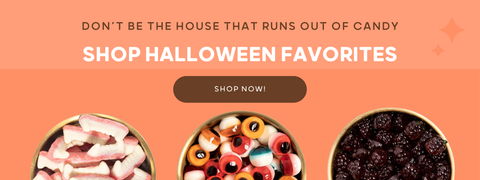 Don't be the house that runs out of candy "shop halloween favorites" with shop now button. gummy eyeballs, fangs, and grapes shown in gold bowls on orange background.