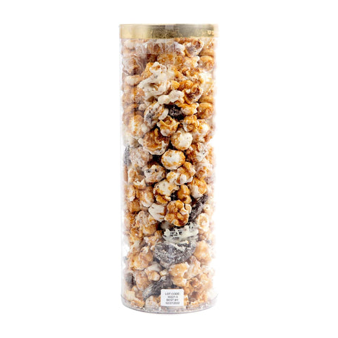 Tall cylindrical container filled with assorted popcorn flavors on a white background